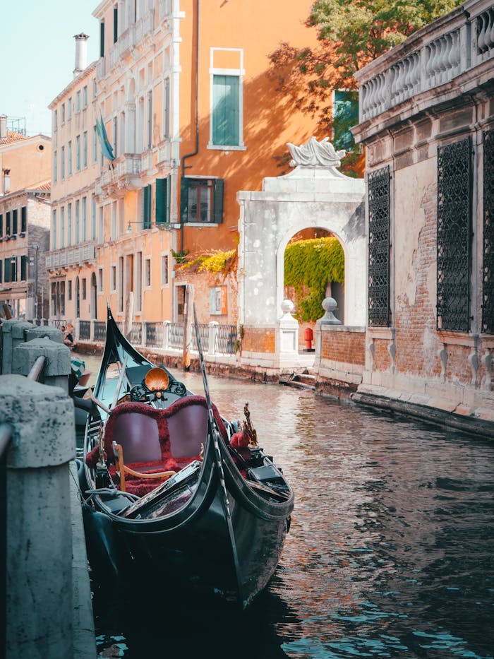 Explore the beauty of a gondola navigating a historic canal in Venice, Italy.